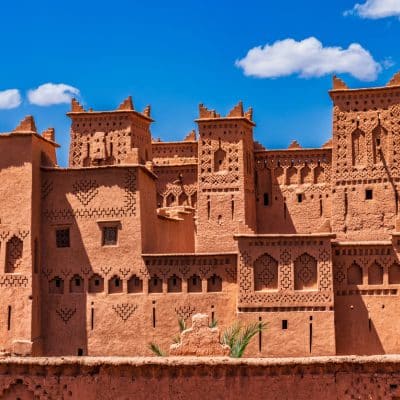 Explora la fascinante arquitectura de las kasbahs marroquíes en nuestros circuitos guiados: primer plano de una construcción de adobe con sus detalles únicos.