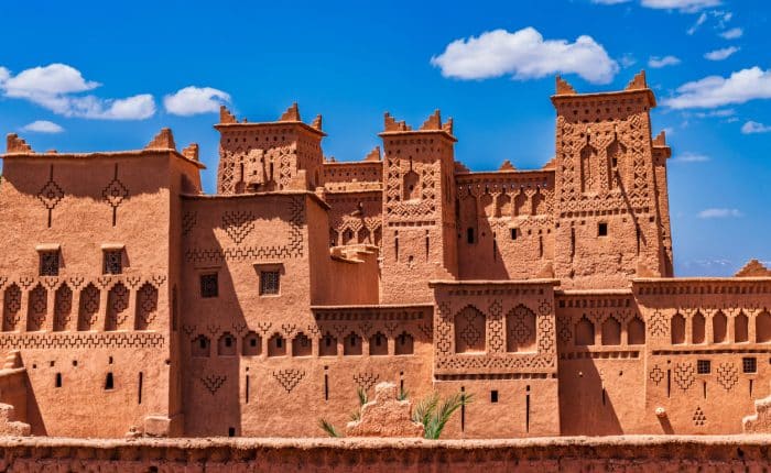 Explora la fascinante arquitectura de las kasbahs marroquíes en nuestros circuitos guiados: primer plano de una construcción de adobe con sus detalles únicos.