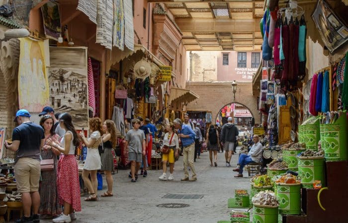 Pasillo estrecho y abarrotado de un zoco, representando el caos del turismo masificado que un viaje a medida diseñado por expertos ayuda a evitar.